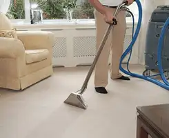Carpet cleaning professional removing dirt and stains with a hot-water extraction tool in a home, Columbus, OH.