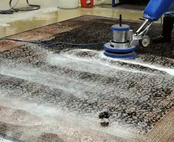 Professional rug cleaning with a rotary floor machine and shampoo foam, deep-cleaning an area rug, in Columbus, OH.